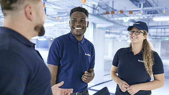 Leadec team talking in factory.