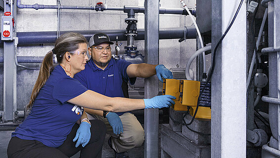 Two Leadec employees inspecting performance of a chem-tech pump.