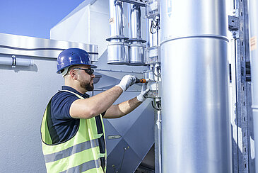 Leadec employee working at ventilation system on a factory roof.